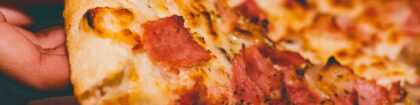Close-Up Photo of Person Holding Pizza