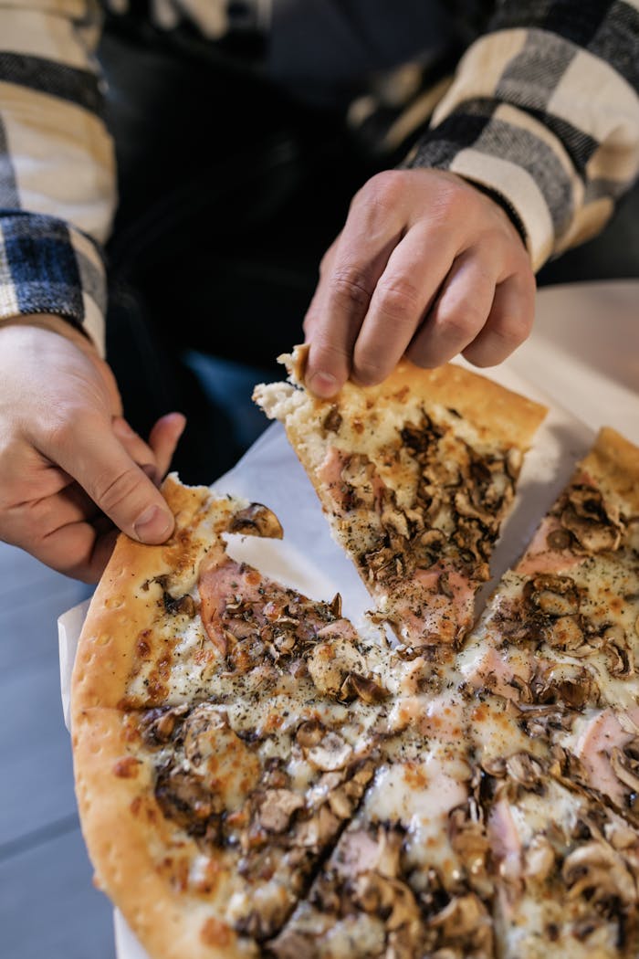 Person Getting a Slice of Pizza